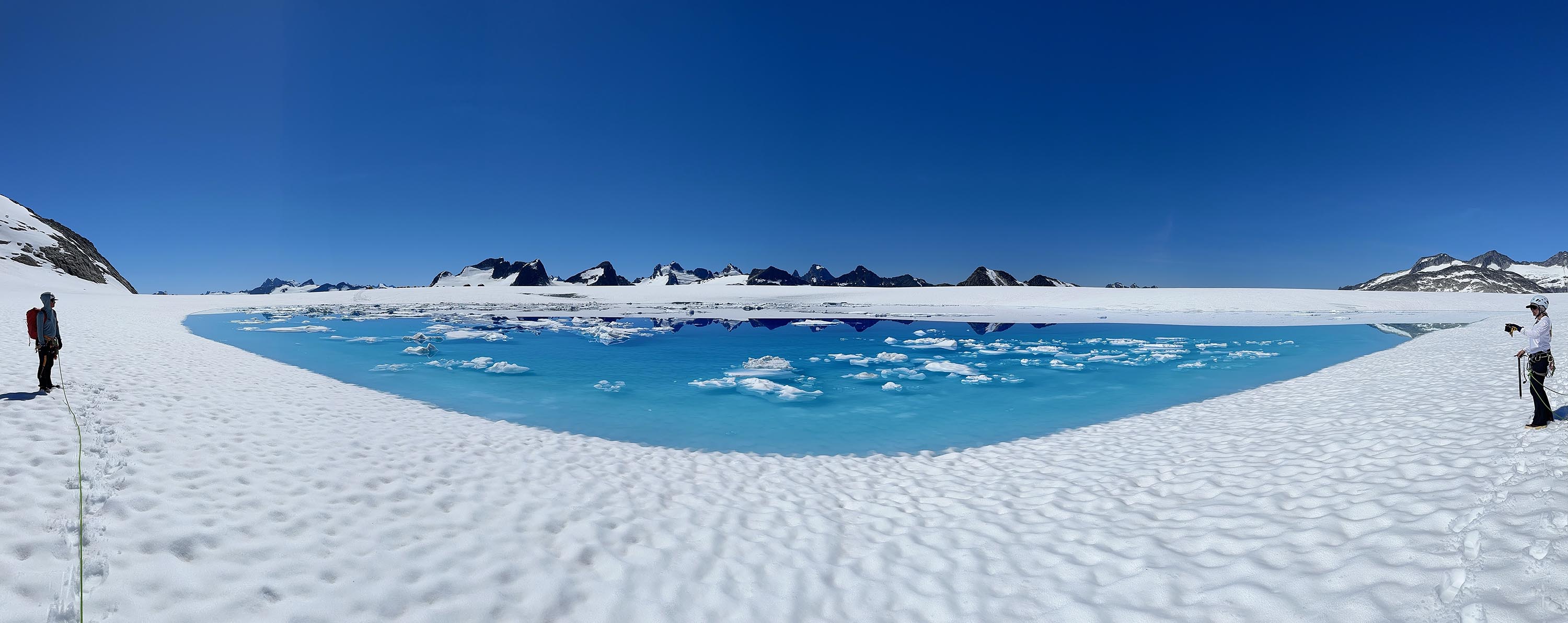 A shows two team members near a supraglacial lake (a body of water on top of the glacier), where biologists could take water samples and compare them to samples taken from the borehole.