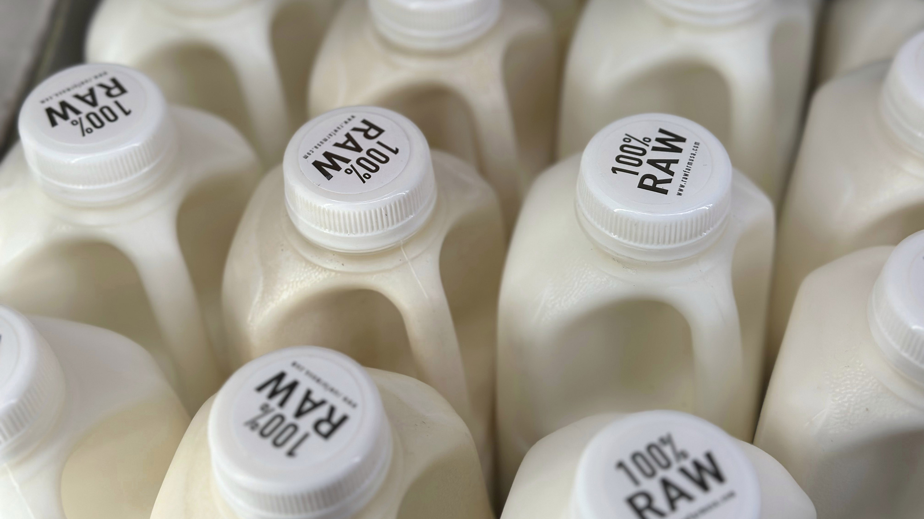 Bottles of raw milk in a grocery store.