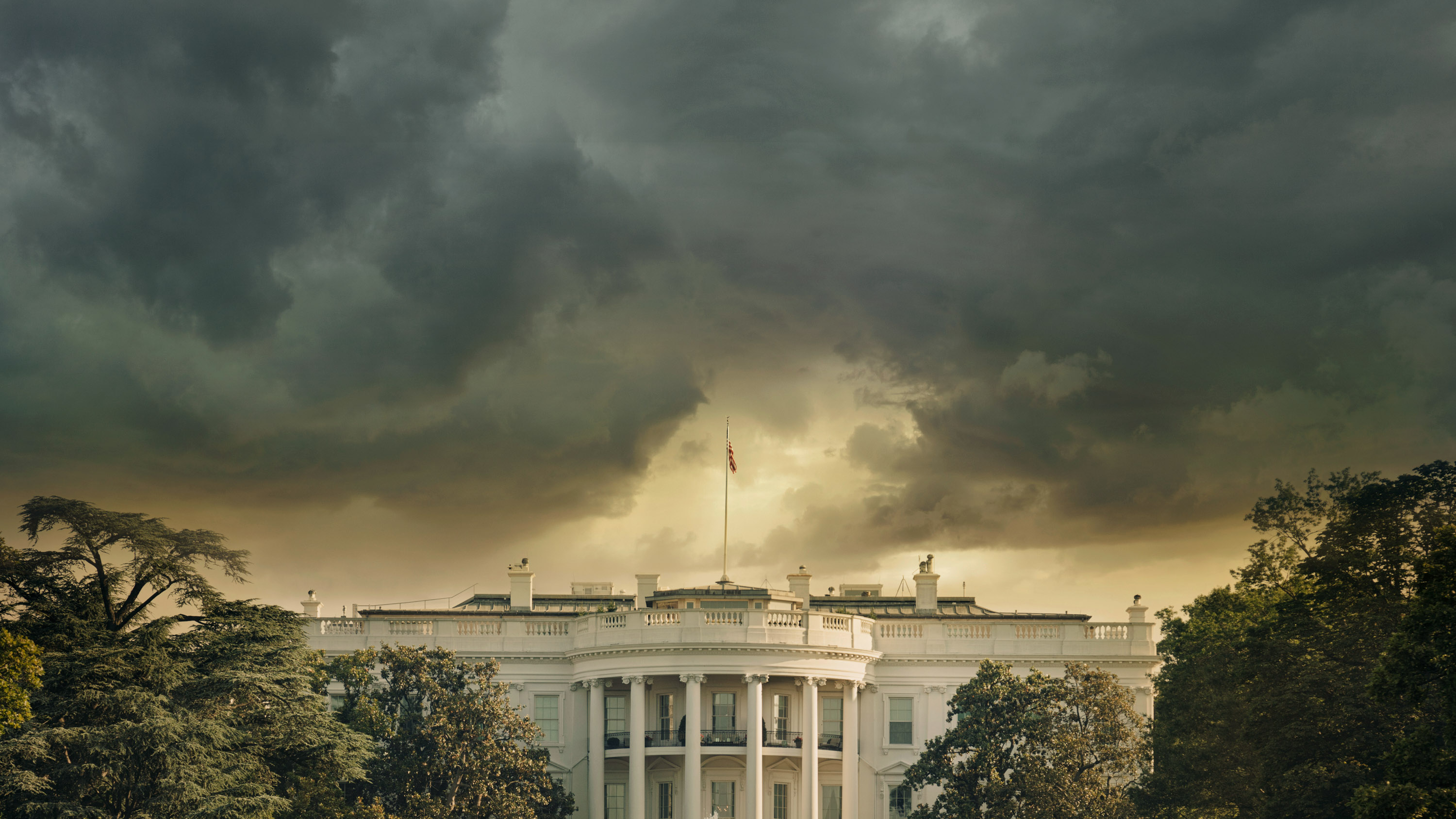 The White House in Washington DC under dark stormy clouds