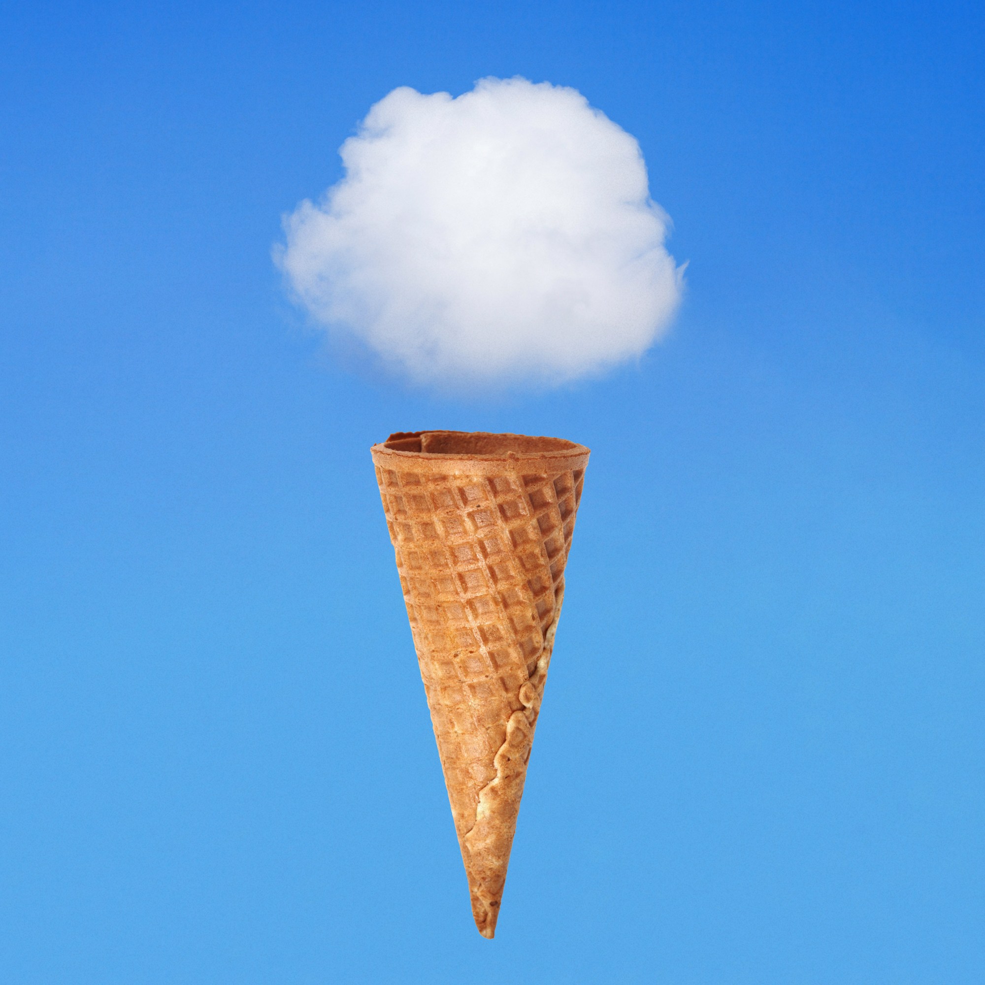 white cloud hovering over a sugar cone on blue sky background