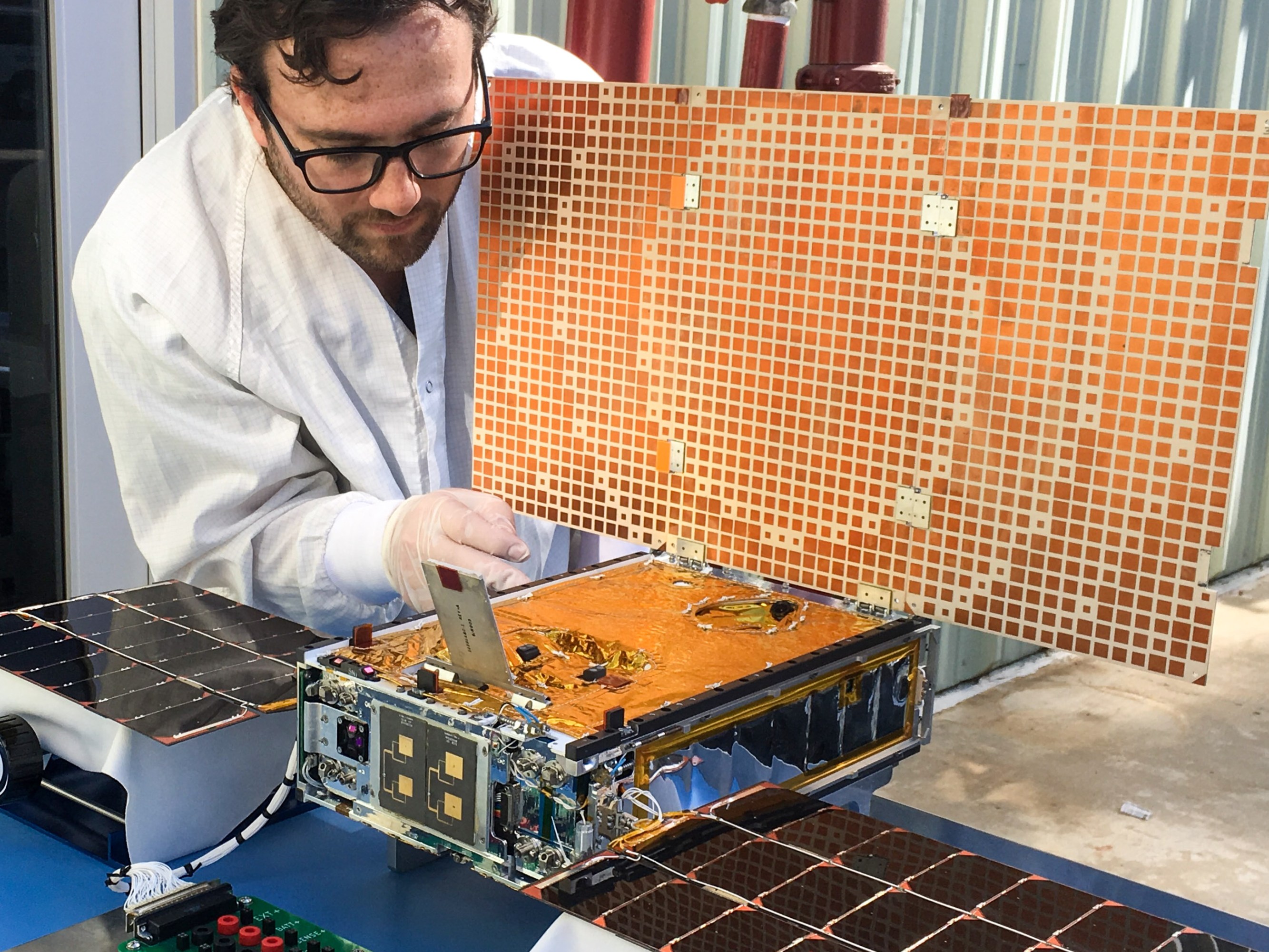 Steinkraus leans toward a solar array on a table.